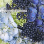 Свадебный букет из голубой гортензии, белых роз и зеленой гвоздики с синими ягодами