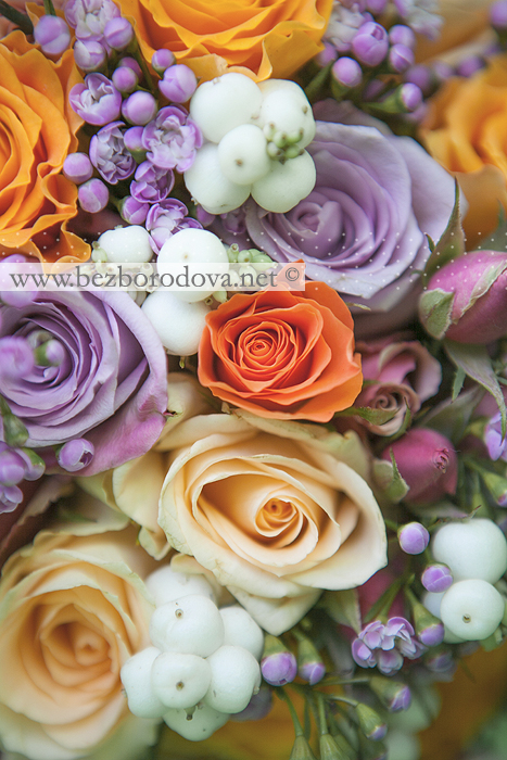 Свадебный букет из оранжевых и сиреневых роз с ягодами