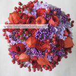 Осенний свадебный букет из красных ранункулюсов и роз с сиреневой гвоздикой и ягодами