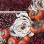 Осенний свадебный букет из бордовых и кремовых роз с ягодами шиповника и эвкалиптом