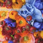 Яркий свадебный букет из оранжевых ранункулюсов с ягодами шиповника и голубой гортензией