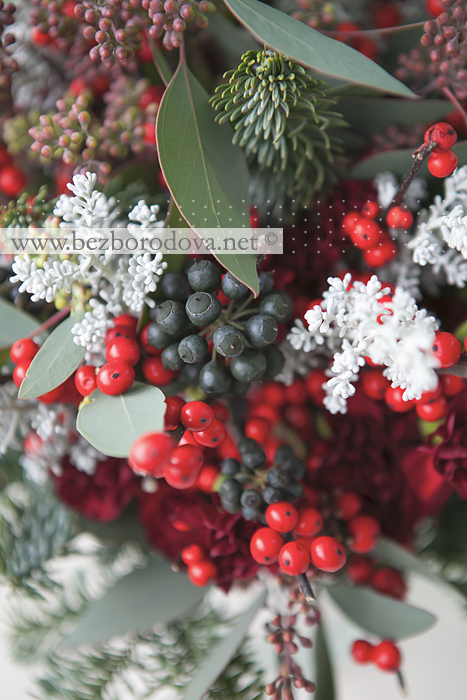 Зимний свадебный букет с красными ягодами, ветками ели и эвкалиптом.