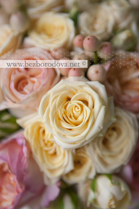 Свадебный букет из персиковых пионовидных роз с ягодами и кустовой розой цвета шампань