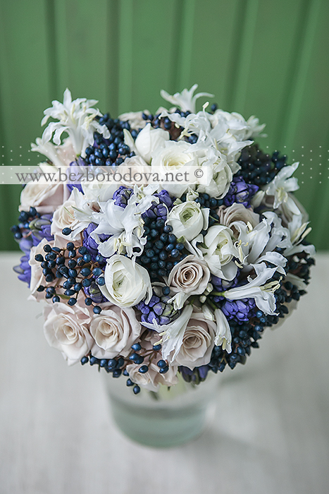 Свадебный букет из белых ранункулюсов, синих гиацинтов и кремовых роз с ягодами