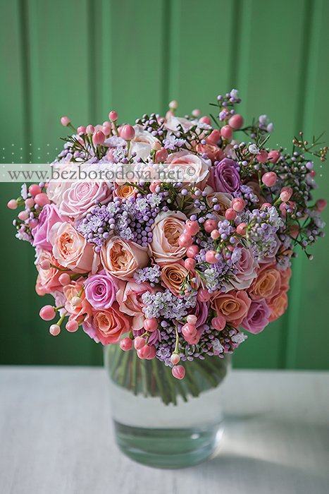 Персиковый свадебный букет из пионовидных роз с ягодами и сиреневым хамелациумом