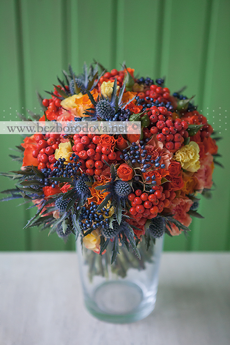 Осенний свадебный букет из оранжевых роз с синим эрингиумом и ягодами рябины