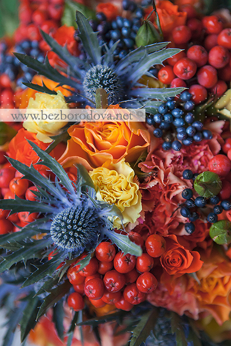 Осенний свадебный букет из оранжевых роз с синим эрингиумом и ягодами рябины