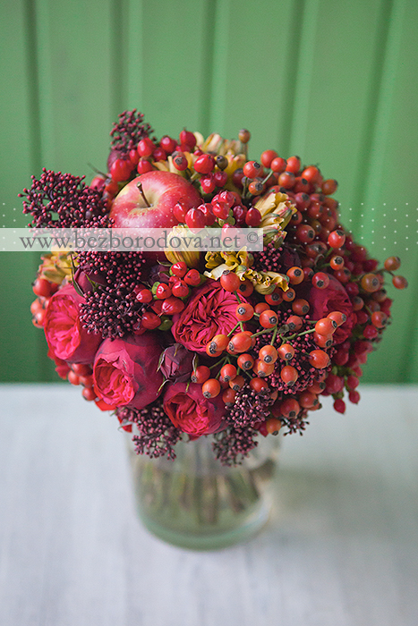 Красный свадебный букет из пионовидных роз с яблоком и ягодами шиповника в стиле хохлома