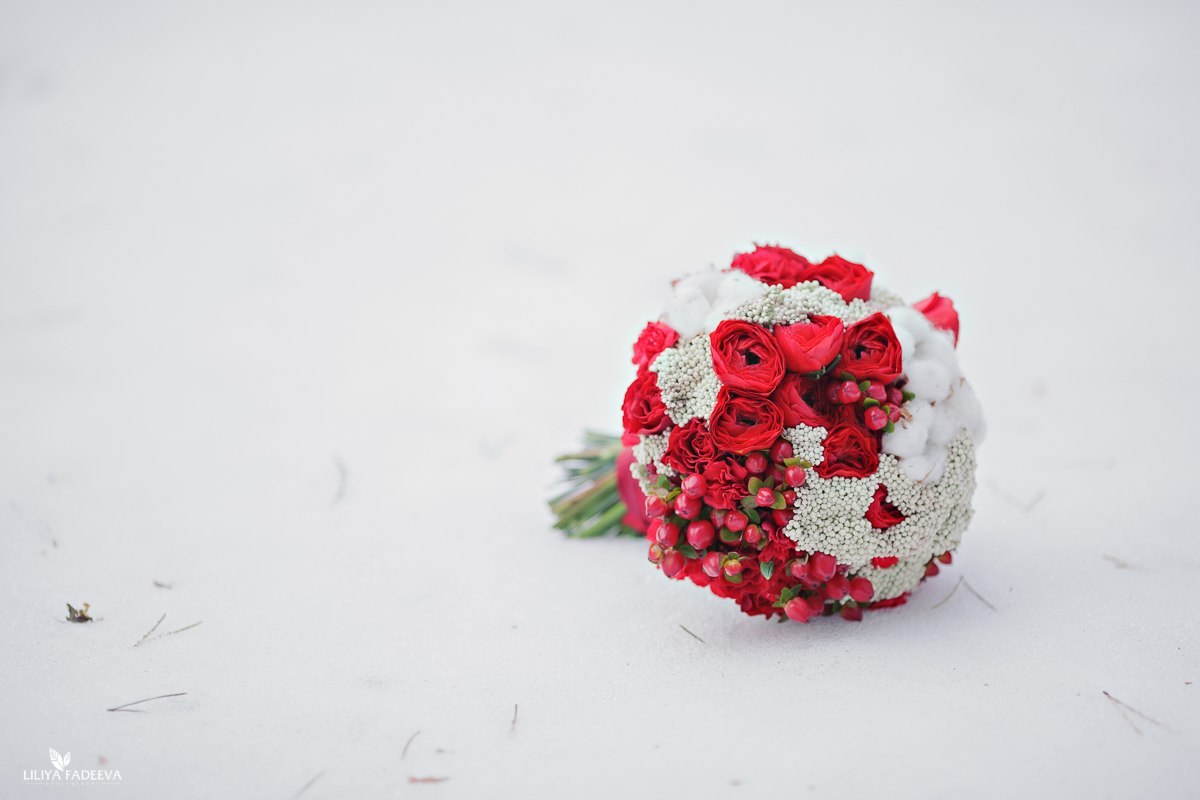 Зимний свадебный букет с хлопком, ягодами и красными ранункулюсами