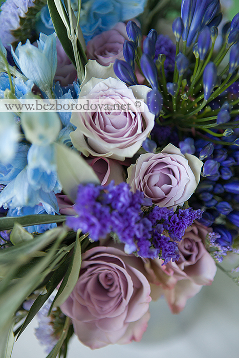 Синий свадебный букет в стиле прованс из агапантуса с голубым дельфиниумом и сиреневыми розами и зеленью оливки