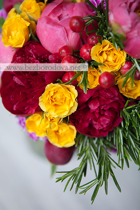 Яркий свадебный букет из пионов винного и кораллового цветов с красными ягодами, желтой розой и розмарином.