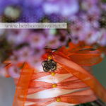 Яркий летний букет невесты из оранжевых и персиковых роз с сиреневой гвоздикой