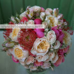 Кремовый свадебный букет из пионовидных роз, кустовой розы, коралловых пионов с красным леукоспермумом
