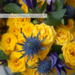 Желтый букет в подарок из кустовых роз, с фиолетовыми клематисами, синим эрингиумом и сиреневой розой