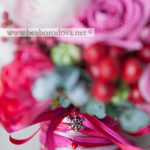 Зимний букет невесты из кремовых ранункулюсов с шишками, красными ягодами, розовыми розами, тюльпанами и эвкалиптом