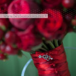 Загружен дляСвадебный букет из красных пионовидных роз с ягодами и перцами