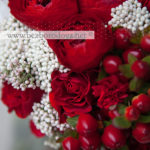 Красный свадебный букет из ранункулюсов, роз, ягод гиперикума с хлопком и белым озотамнусом