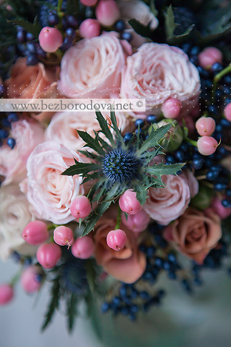 Необычный свадебный букет из пионовидных кремовых роз , синих ягод вибурнума, персиковых ягод гиперикума, коричневых роз и эрингиума
