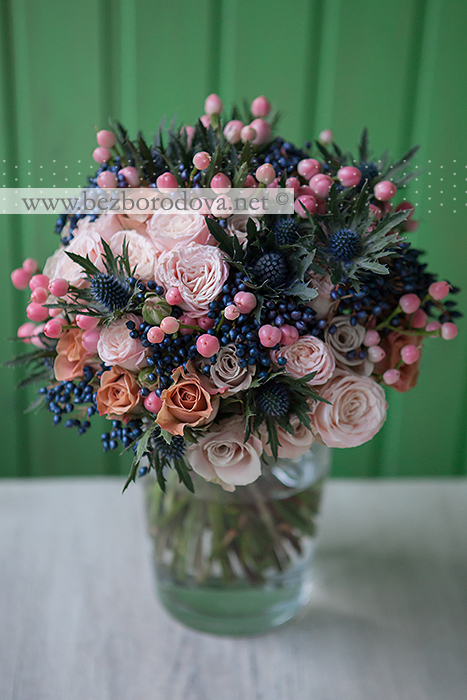 Необычный свадебный букет из пионовидных кремовых роз , синих ягод вибурнума, персиковых ягод гиперикума, коричневых роз и эрингиума
