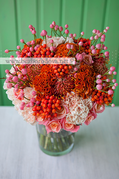 Яркий осенний свадебный букет с ягодами рябины, оранжевой целозией, персиковой гвоздикой и леукосперумом