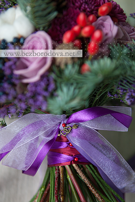Зимний свадебный букет с хлопком, шишками, ветками ели, синими и красными ягодами, сиреневыми розами и винной хризантемой