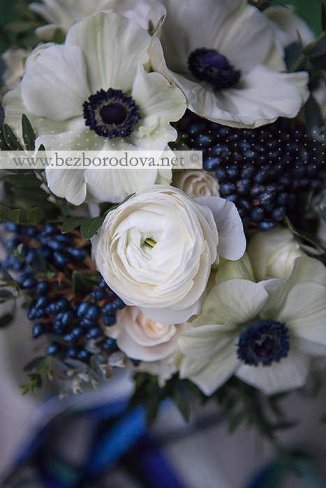 Белый свадебный букет из ранункулюсов, анемонов, пионовидных роз, фрезий и синих ягод вибурнума с мятной зеленью эвкавлипта