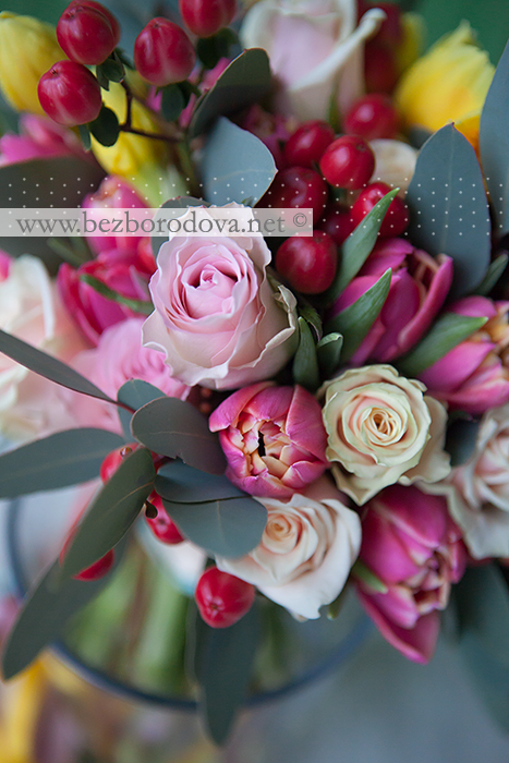 Яркий весенний букет невесты из розовых роз с тюльпанами, желтыми нарциссами и красными ягодами гиперикума