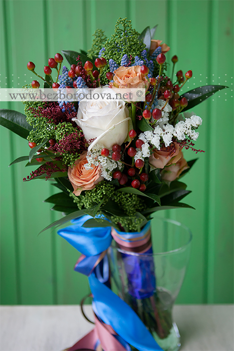 Свадебный букет свободной формы из коричневых роз, ягод гиперикума с голубыми мускари и зеленой скиммией