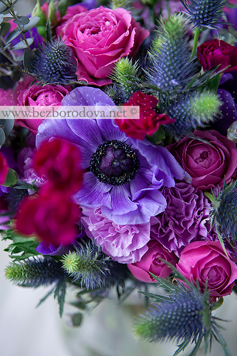 Букет из малиновых пионовидных роз, сиреневой гвоздики с синими эрингиумами и фиолетовыми анемонамии